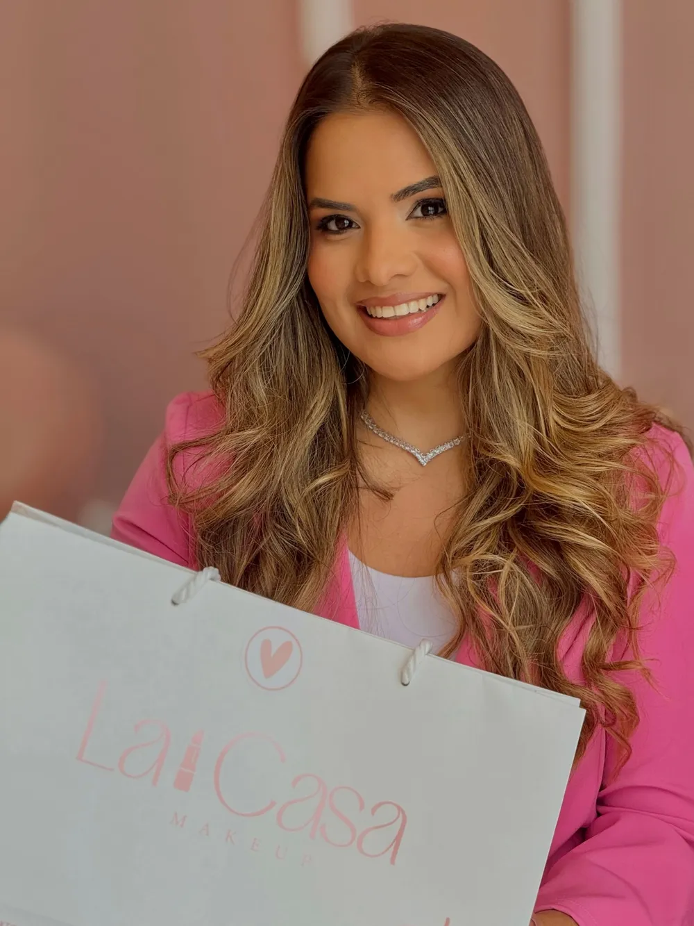 Thamyris Montenegro Nóbrega, fundadora da La Casa Makeup, segurando uma sacola da loja